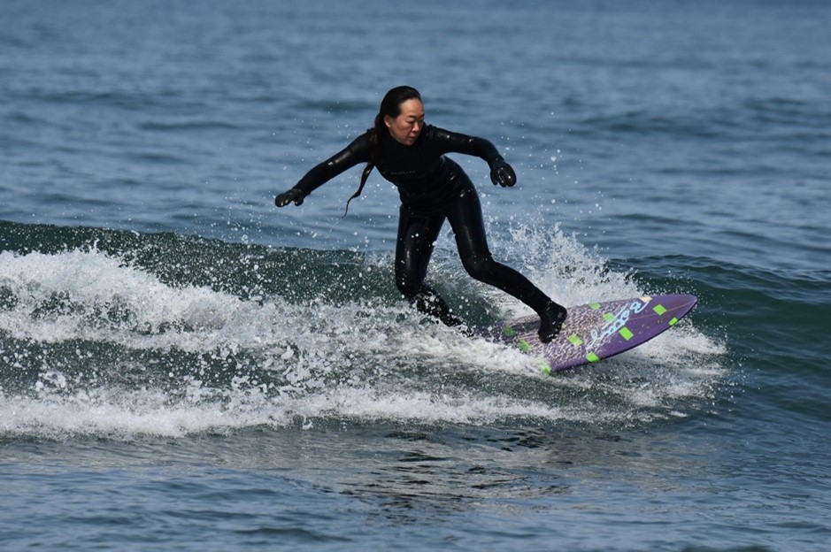 Mulher surfista com roupa de mergulho preta