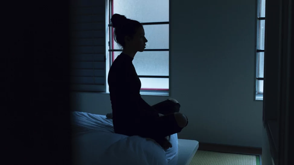 woman sitting on the edge of bed