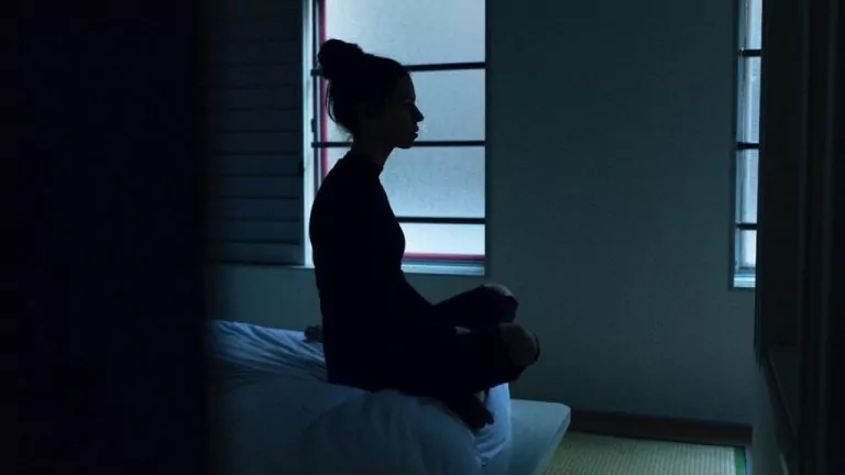 Girl sitting on bed scaled