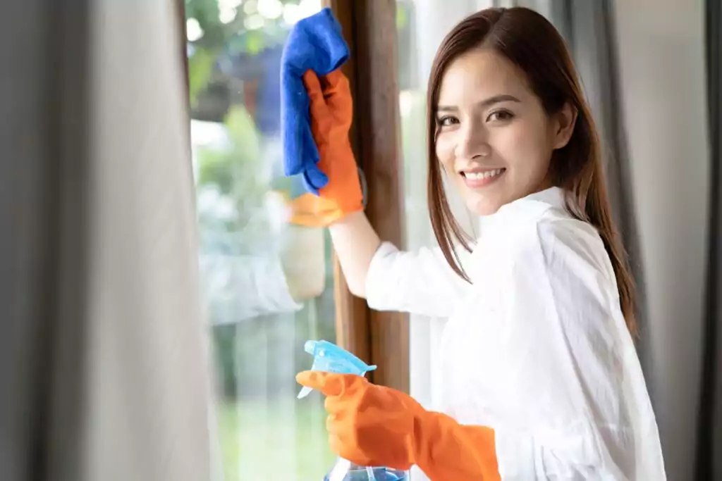 窓の拭き掃除をする女性